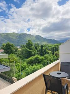 Un balcón con mesa y sillas y montañas. en Guesthouse Villa Stanovic Vlaho, en Cavtat