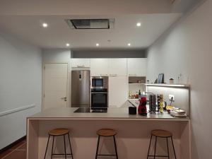 a kitchen with a counter and two bar stools at Pagés in Sant Climent Sescebes