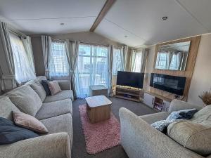 a living room with couches and a flat screen tv at Beautiful 6 Berth Caravan, Nearby Beach In Suffolk Ref 68016Bs in Lowestoft