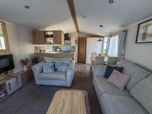 a living room with two couches and a kitchen at Beautiful 6 Berth Caravan, Nearby Beach In Suffolk Ref 68016Bs in Lowestoft