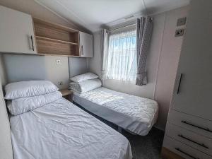 a small room with two beds and a window at Beautiful 6 Berth Caravan, Nearby Beach In Suffolk Ref 68016Bs in Lowestoft +14 photos