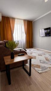 a living room with a table and a couch at Квартира 6-35 in Aktau