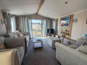a living room with couches and a tv at Stunning 6 Berth Caravan At Suffolk Sands Holiday Park Ref 45031G in Felixstowe