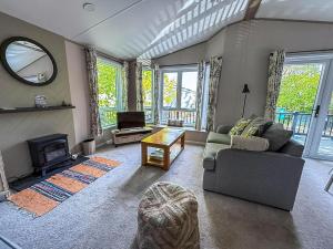 a living room with a couch and a fireplace at Beautiful Lodge With Decking At Azure Seas In Suffolk, Sleeps 6 Ref 32217Og in Lowestoft