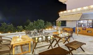 un patio con mesas y sillas por la noche en Uno prime kasol, en Kasol