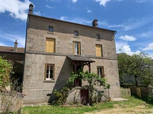 a large brick building with a gate in front of it at Gite Chez Charles in Bersac-sur-Rivalier