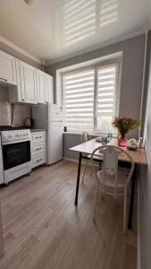 a kitchen with a table and a table and chairs at Квартира 6-35 in Aktau