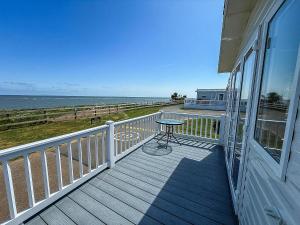 a balcony with a table and a view of the ocean at Beautiful 6 Berth Caravan With Stunning Sea Views In Suffolk Ref 68029Cr in Lowestoft