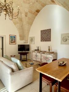 a living room with a table and a couch at Dimora Orsini del Balzo in Carovigno