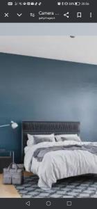 a bedroom with a bed with a blue wall at Villa Porto fossa 2 in Marzamemi