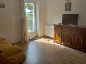 a bedroom with a tv on a dresser and a window at Belle vue in Roussennac