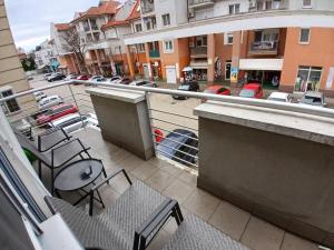 a balcony with chairs and a parking lot with buildings at Solis Residence in Hajdúszoboszló