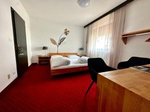 sypialnia z łóżkiem i czerwonym dywanem w obiekcie Landhotel Anna w mieście Silandro +37 zdjęć