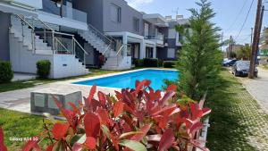 a swimming pool in front of a building at Perla Beach Apartments in Ofrínion