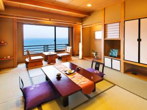 a living room with a table and a view of the ocean at Ryugu Hotel in Nishio