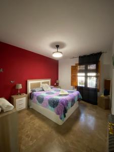 a bedroom with a bed and a red wall at La Casa Del Buda in Güéjar-Sierra