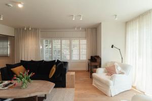 a living room with a couch and a table at Villa 'La Mer Veille - Bécassine' in Oostduinkerke - Bad in Oostduinkerke