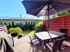 a table and chairs with an umbrella on a deck at Cozy townhouse apartment in Kerava