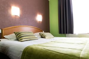 Postel nebo postele na pokoji v ubytování Hotel Cheval De Bronze
