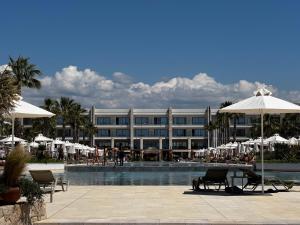 a resort with a swimming pool with chairs and umbrellas at Next to Melia-Premium Zone, Private Garden Apartment - SanPietro Resort in Draçi