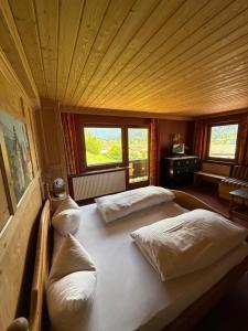 a bedroom with two beds in a room with windows at Häusl am Roan Reutte Höfen in Hofen