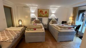 a bedroom with two beds and a desk with a lamp at Ferienwohnung am Sonnenstein in Brehme