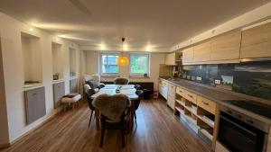 a kitchen with a table and some chairs in a room at Ferienwohnung am Sonnenstein in Brehme +16 photos