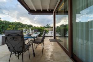 a patio with a table and chairs and a view of the water at Isola Country House - Villa by the beach in Plemmirio