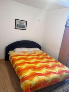 a bedroom with a bed with a colorful comforter at Sobe i Apartmani Svjetlana-Mladen Okuka in Višegrad