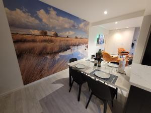 a dining room with a large painting on the wall at d'Ereplatse in Zuienkerke