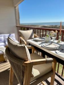a dining table and chairs on a balcony with the ocean at Direct Luxury Oceanfront - On The Beach! Amazing Sunrises, 2 Pools & Bar! in Hilton Head Island