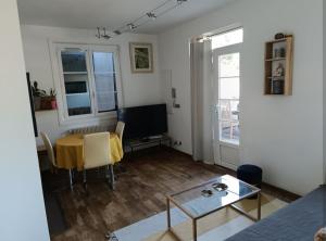 a living room with a table and a television at T3 Zen in Ciboure