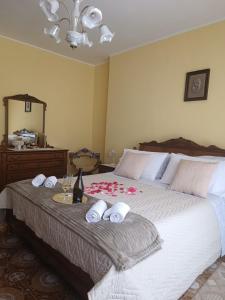 a bed with towels and a bottle of wine on it at Via San Vincenzo, 21 in Castiglione di Sicilia
