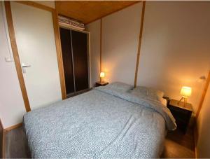 a bedroom with a bed and two lamps on tables at Chalet dans le Perche in Soligny-la-Trappe