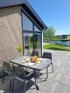 un tavolo e delle sedie seduti su un patio di De IJssel Eilanden Chalet Casa Kampen mit Zaun Nr 548 a Kampen