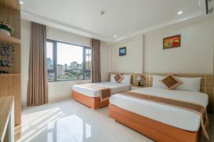 a hotel room with two beds and a window at Sail Hotel Hạ Long in Ha Long