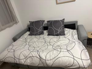 a bed with black pillows on top of it at Nice tourist apartment in Digoin