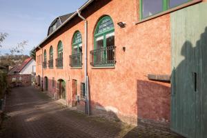 an orange building with green windows on a street at Ferienwohnung am Sonnenstein in Brehme