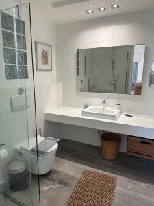 a bathroom with a sink and a toilet and a mirror at Villa Thalia Floating Heaven in Porto Heli +30 photos