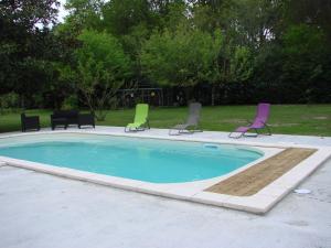 a group of chairs and a swimming pool at B&B Le Magnolia in Saucats