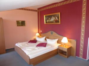una camera da letto con un letto con una parete rossa di Hotel Koos a Putbus