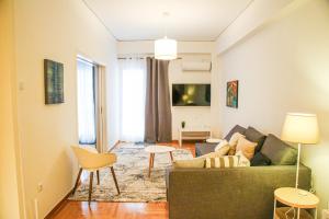 a living room with a green couch and a table at Plaka City Centre Athens Flat in Athens