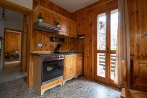 a kitchen with wooden walls and a stove top oven at Chalet Del Rio in Fiumalbo