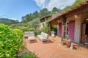 un patio con mobili bianchi su un cortile in mattoni di Charme provençal Les amandiers piscine et animaux a Solliès-Toucas
