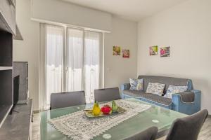 a living room with a glass table and a couch at Loano Top Flat in Loano +7 photos
