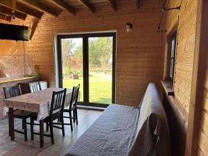 a dining room with a table and chairs and a window at Domki nad Szelągiem in Kątno
