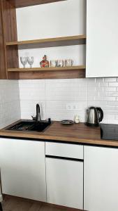 a kitchen counter with a sink and a stove at Флора in Almaty