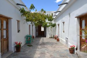 a hallway of a white building with potted plants at Hosteria Villa Cardon in Cachí