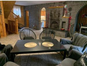 a living room with a table and chairs and a fireplace at Dom całoroczny nad jeziorem Sawinda in Woszczele