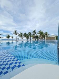 a swimming pool with palm trees in the background at Pebble Peninsula Resort in San Francisco +29 photos